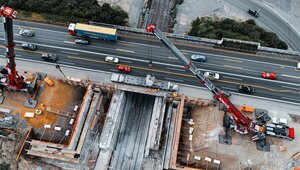 Das Drohnenfoto zeigt, wie an der Autobahnbaustelle Oberhausen-Sterkrade mit zwei Autokranen gearbeitet wird. Foto: Autokrane Schares GmbH / Alex Gruber Gruber-Fotografie