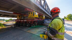 SPMTs, auch "Tausendfüßler" genannt, fahren die Brücke Stück für Stück über die Lippe. Foto: medienwerk